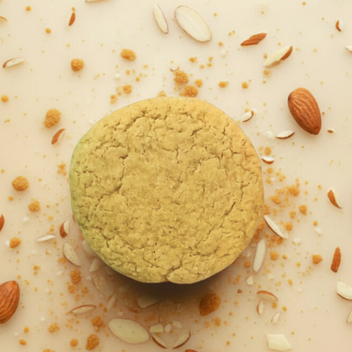 tan cookie with almonds on a light background