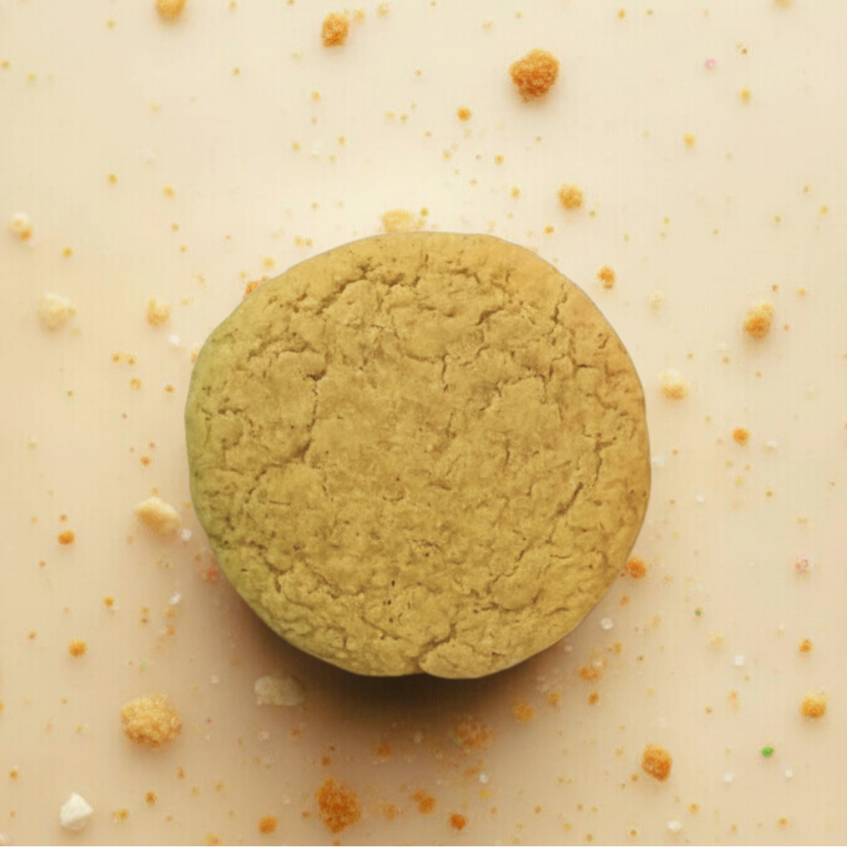 tan cookie on a beige surface with crumbs